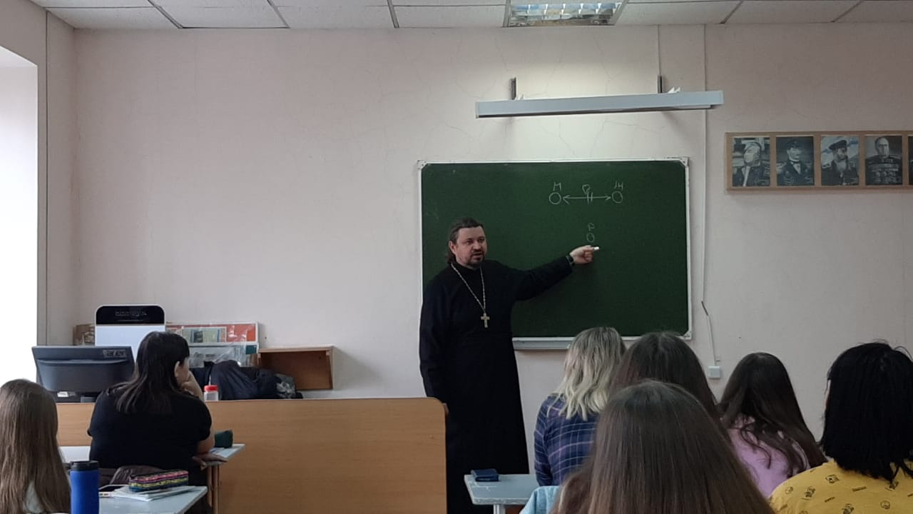 Священник беседует со студентами о семейных ценностях.